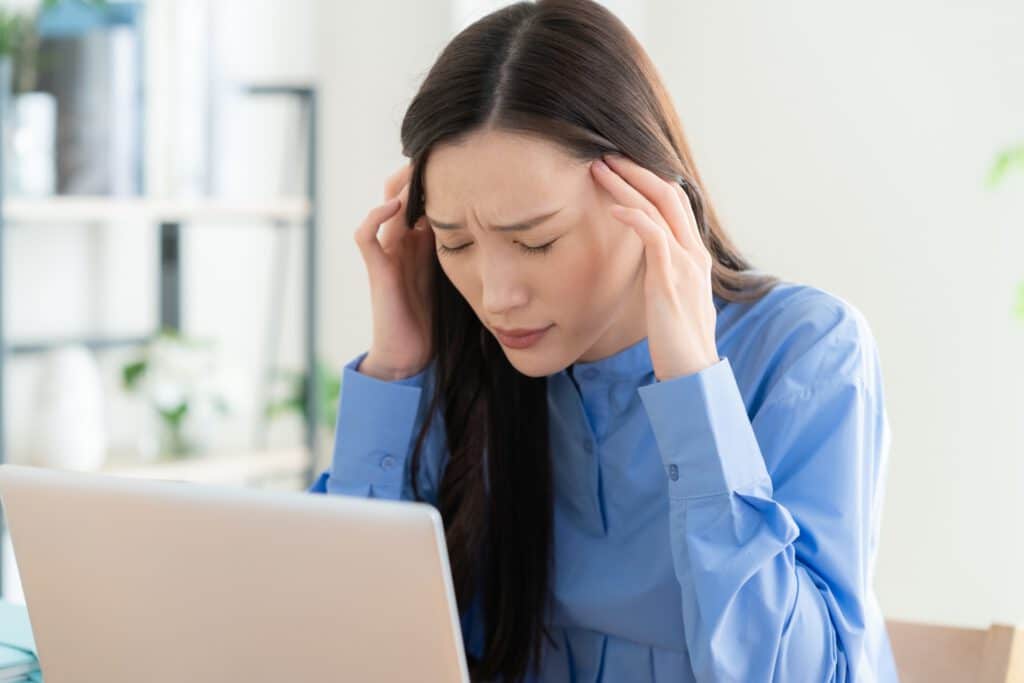 女性が頭が痛そうにしている