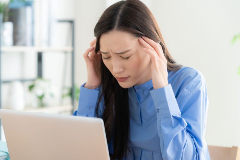 女性が頭が痛そうにしている